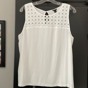 White sleeveless blouse with cutout yoke.